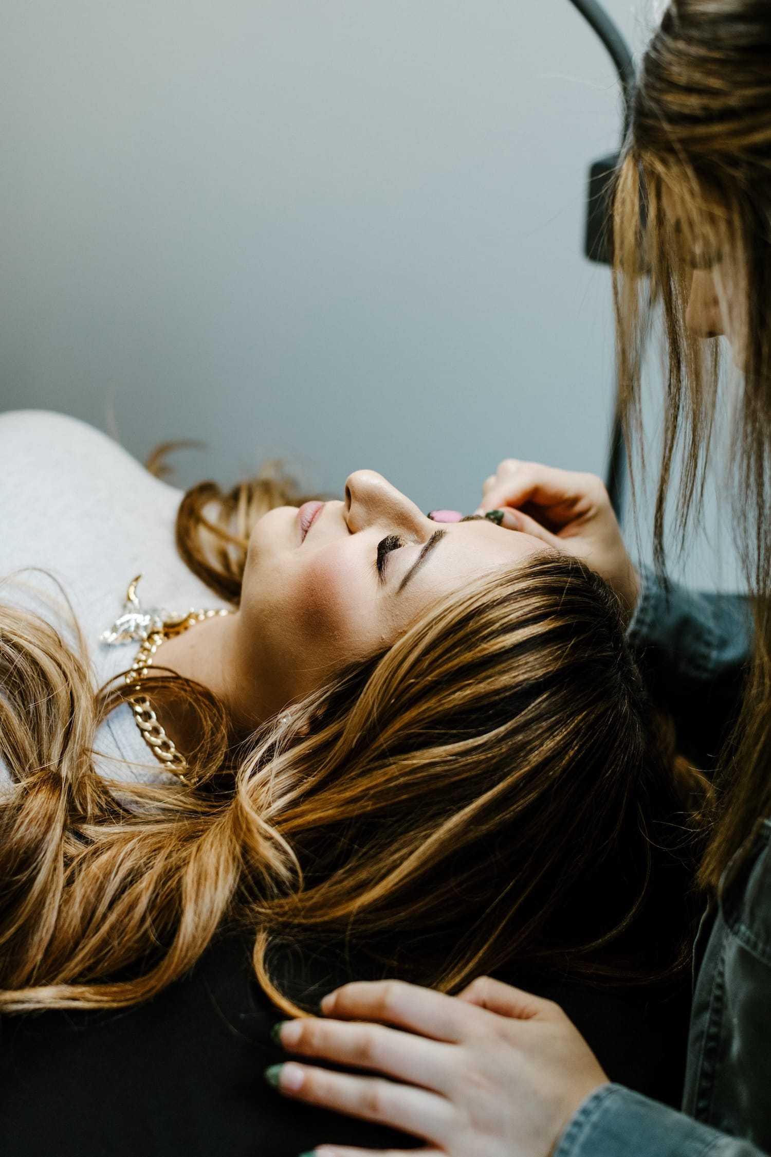 A woman getting her makeup done by a makeup artist.