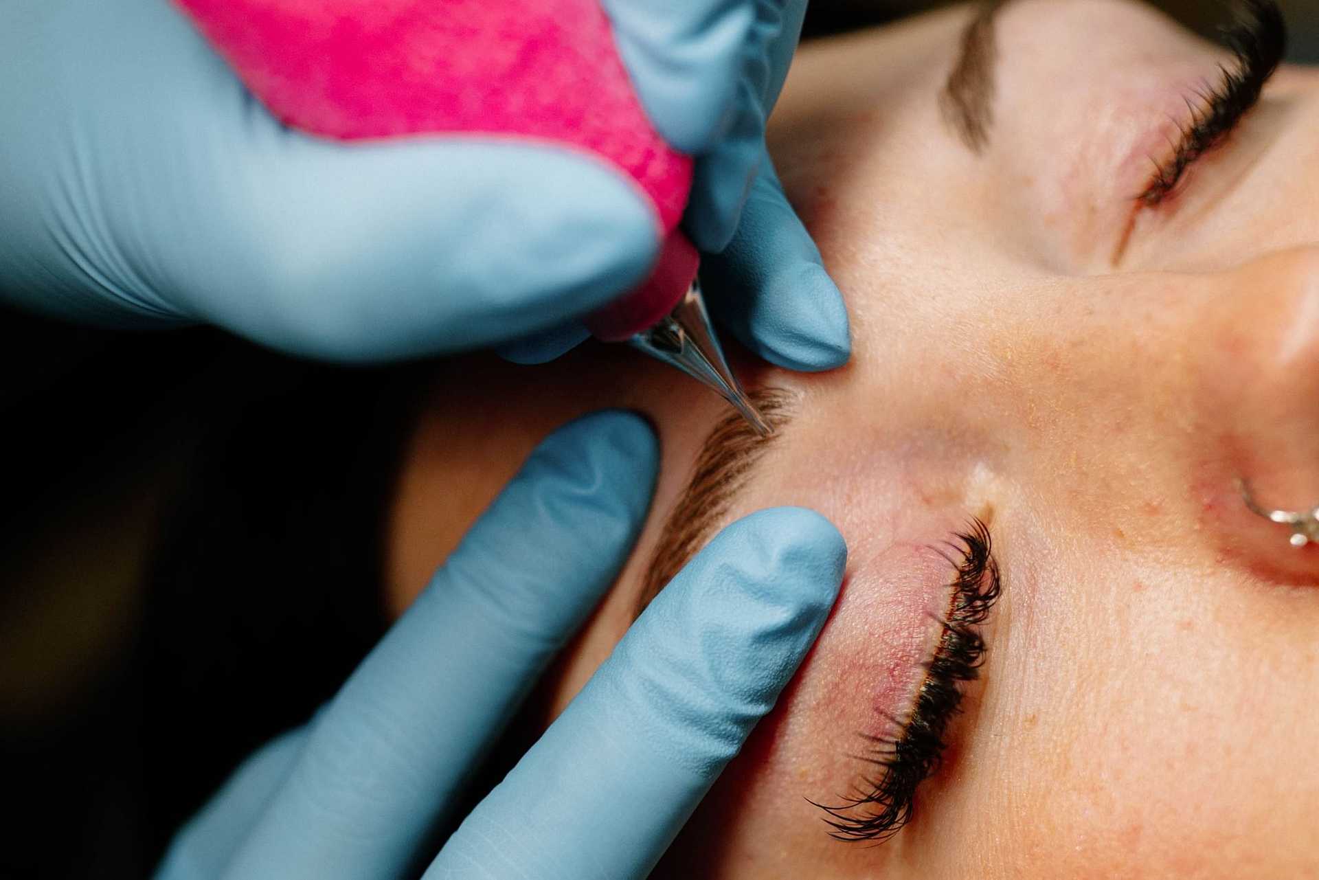 Aesthetician performing a facial treatment on a client.