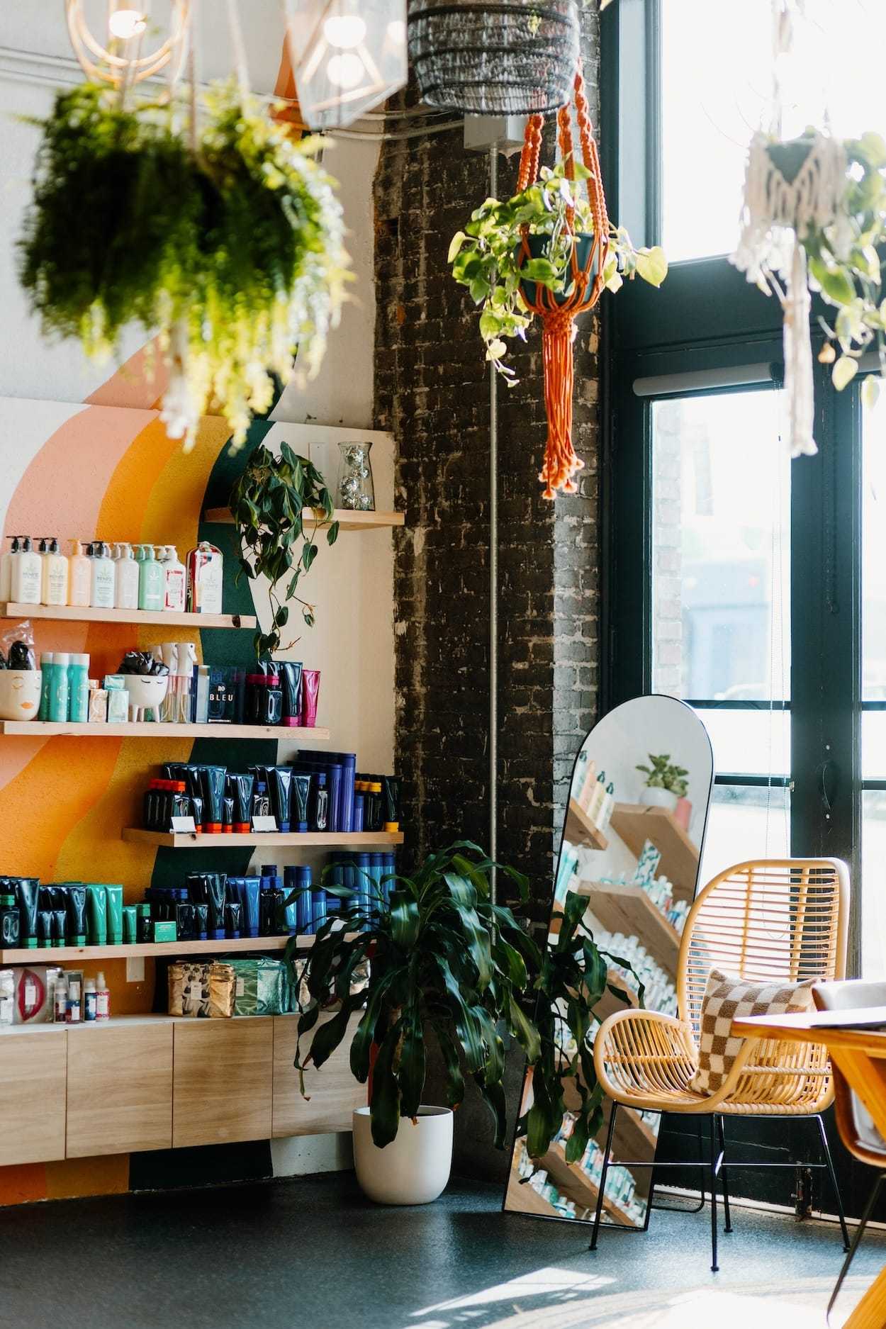 A cozy plant-filled corner of a boutique with products displayed.